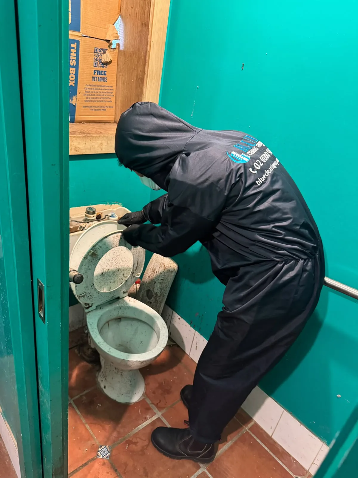 A cleaner in a hooded Blue Cleaning Group coverall