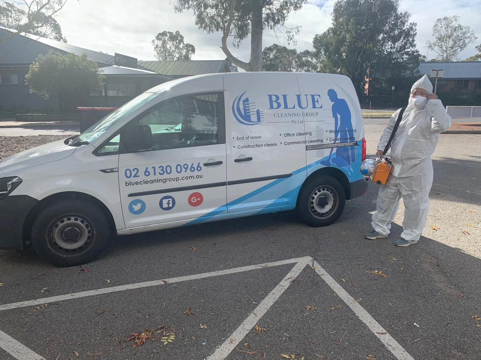 A worker in a full white disposable coverall